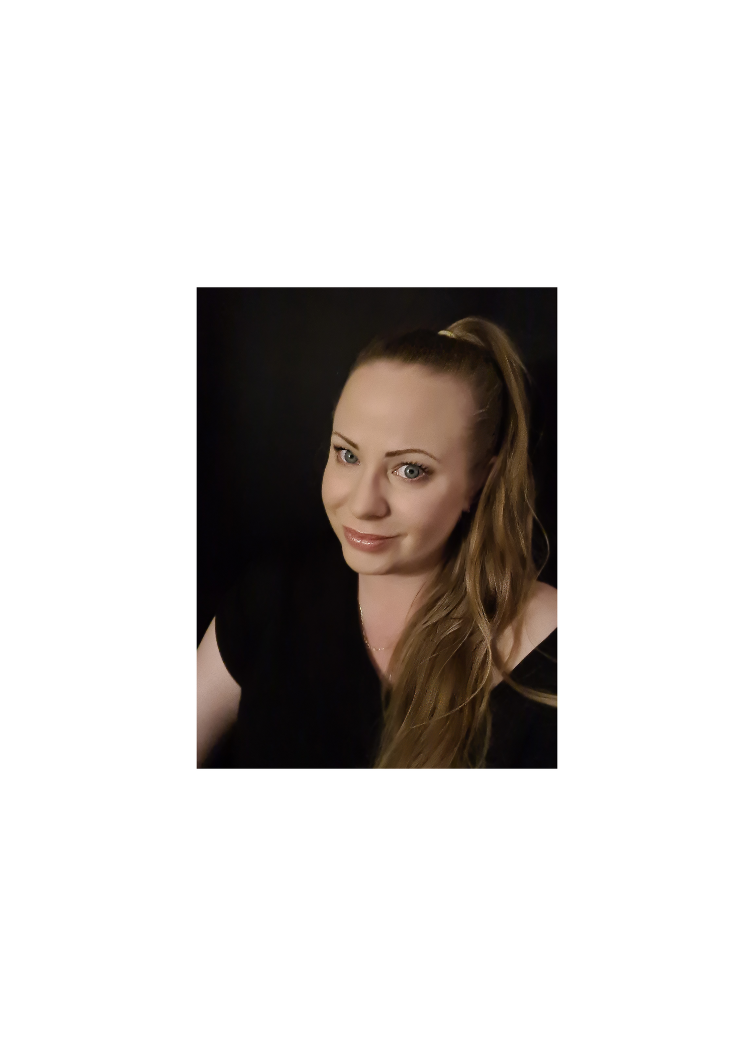 Woman with long hair in a high ponytail wearing black shirt in front of black background.