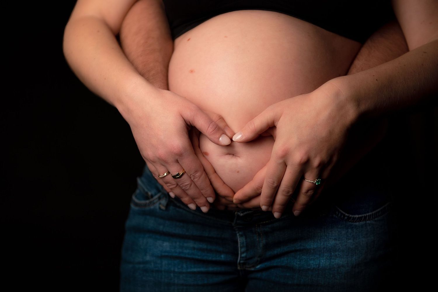 Foto's zwangerschap waarbij papa en mama handen op de buik leggen