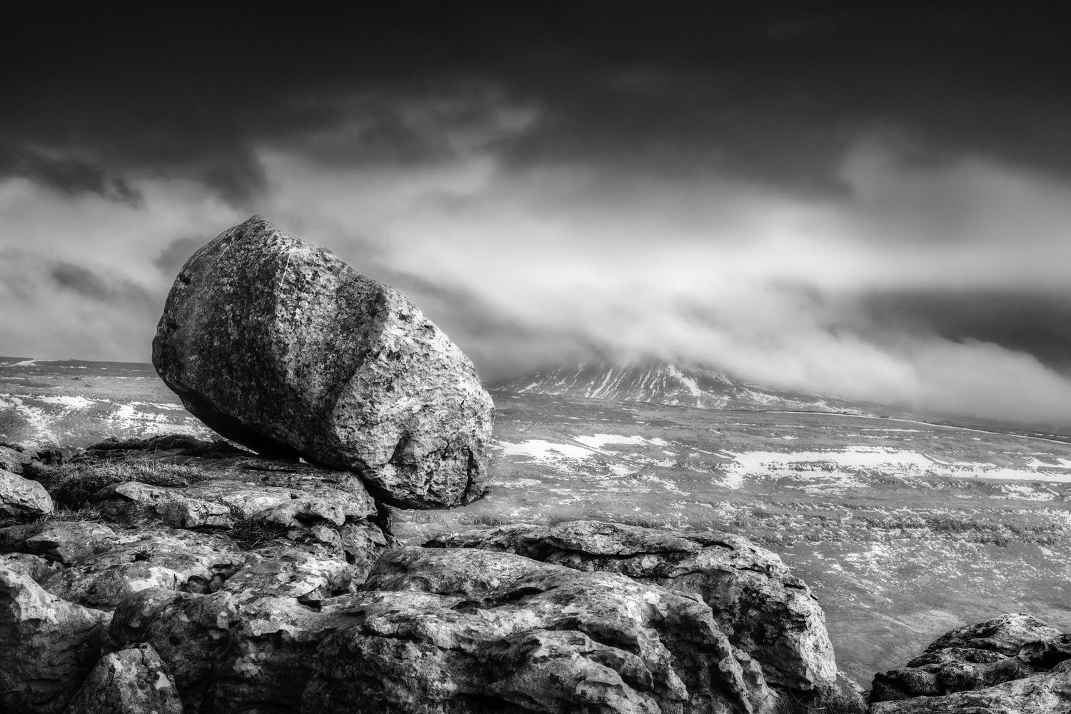 Balanced glacial erratic above Kingsdale with Ingleborough in the background