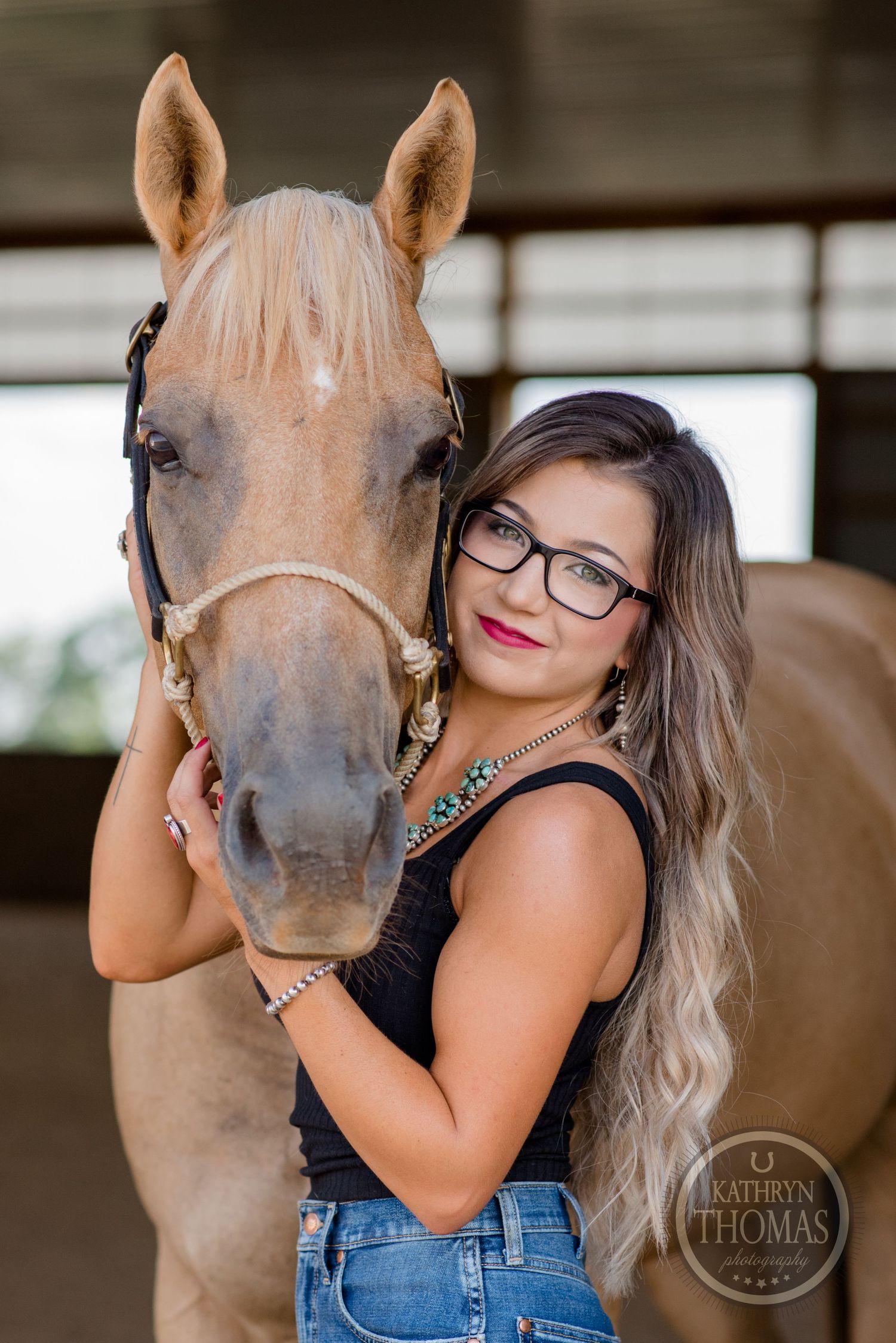A gentle portrait of a palomino horse with its handler in a stable setting.