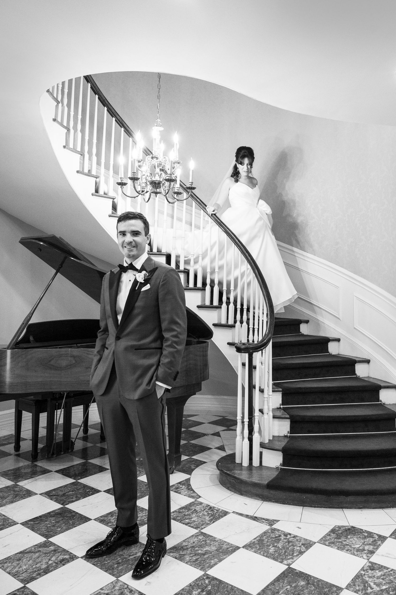 The bride gracefully descends the stairs, making her way to meet the groom during their first look.