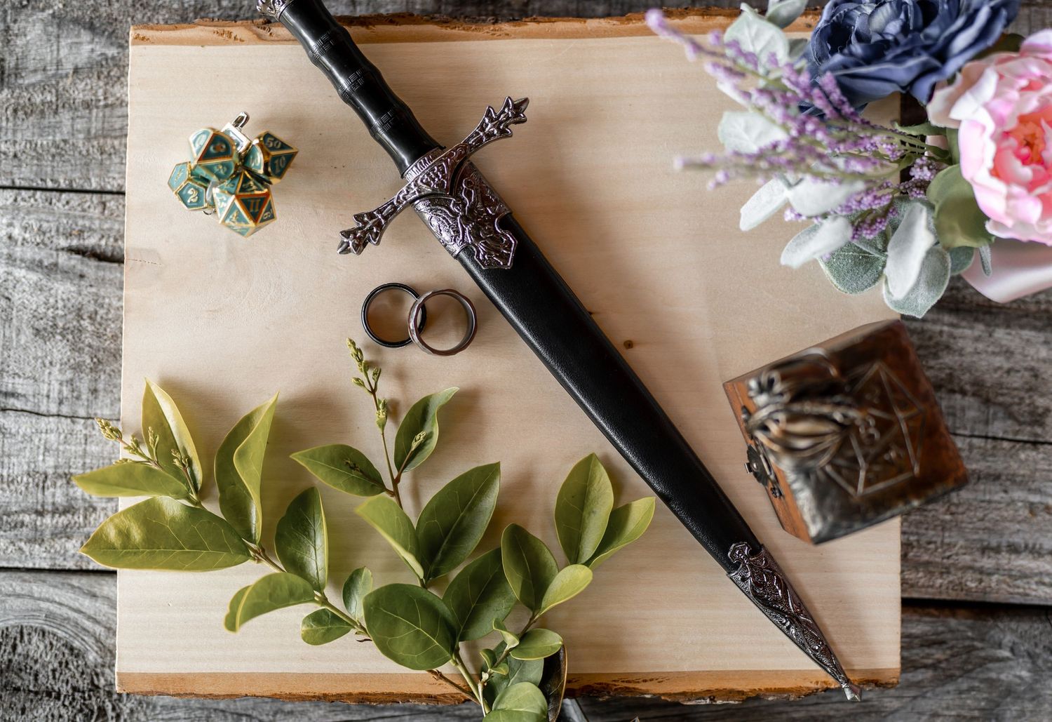Wedding rings, flowers, and decorative elements arranged on a rustic wooden surface.