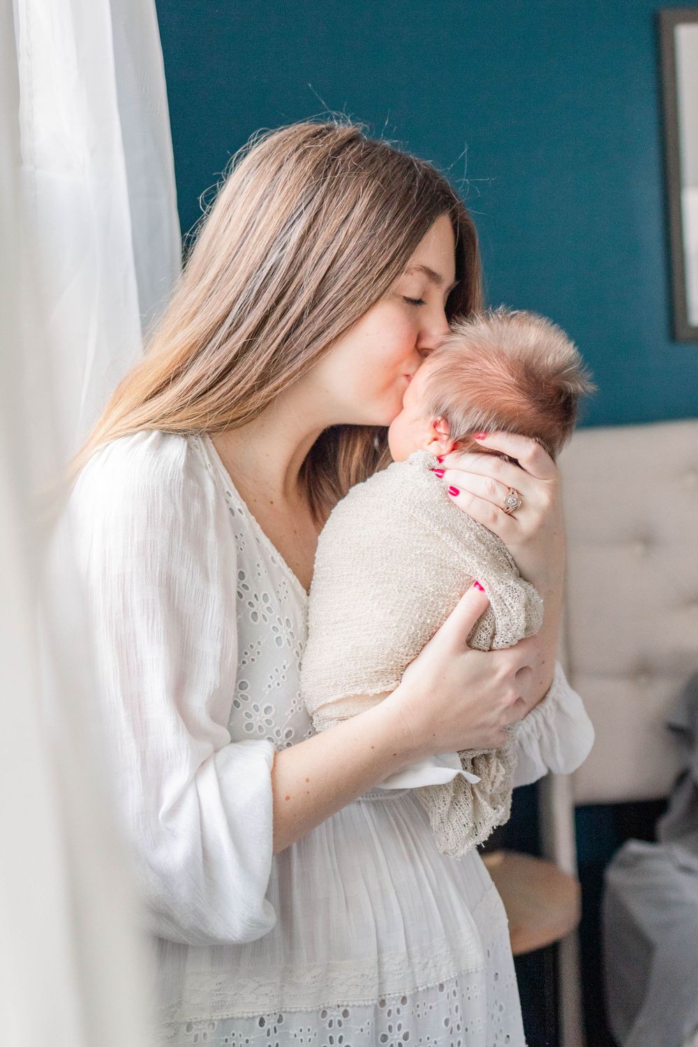 Image of a new mother holding her newborn during a lifestyle newborn session