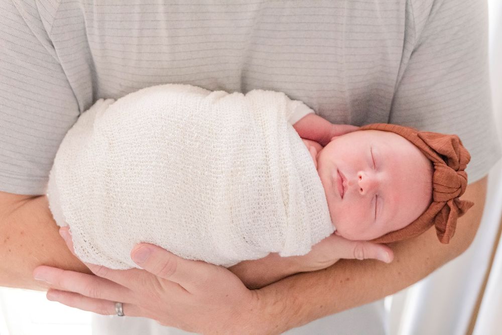 Father holding his newborn during an in home lifestyle newborn session in Cincinnati