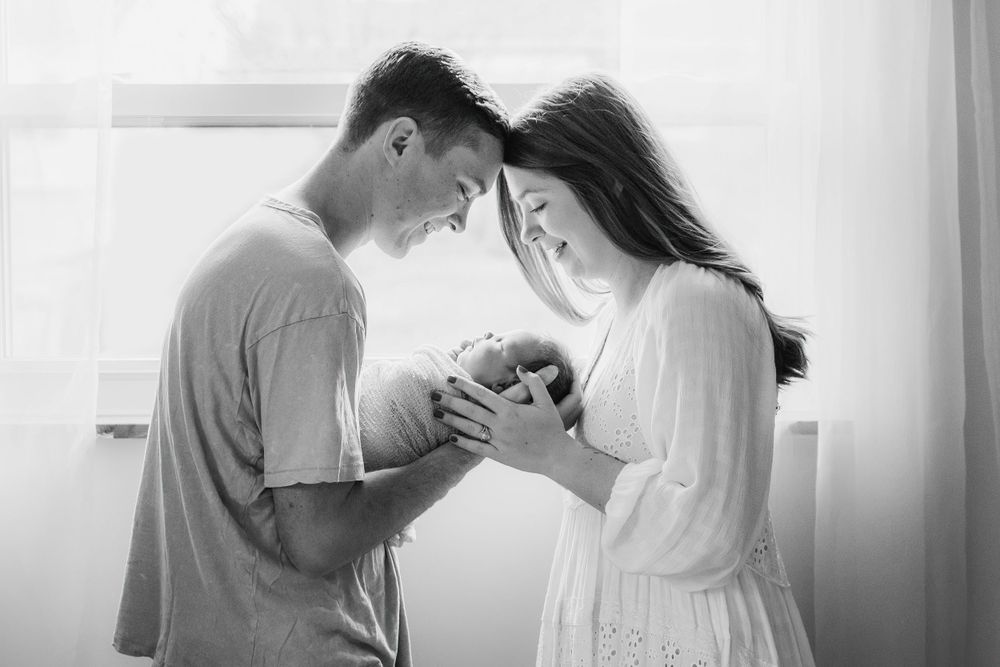 New parents holding their newborn during a lifestyle newborn session in Cincinnati