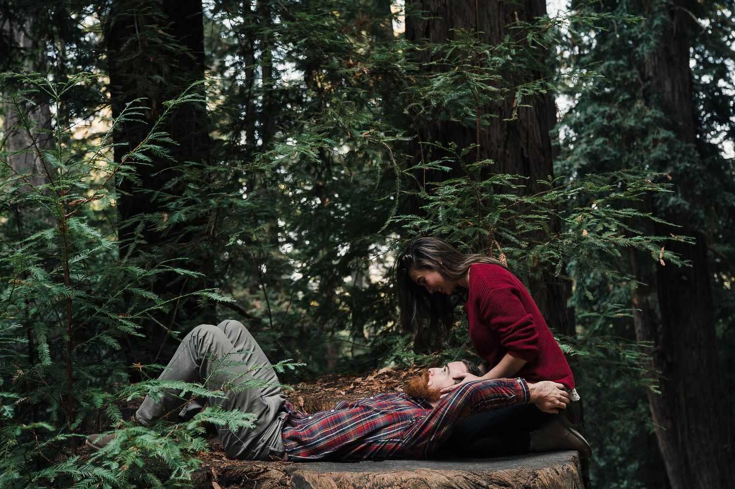 A dramatic scene unfolds on a wooden platform in a dense forest setting.