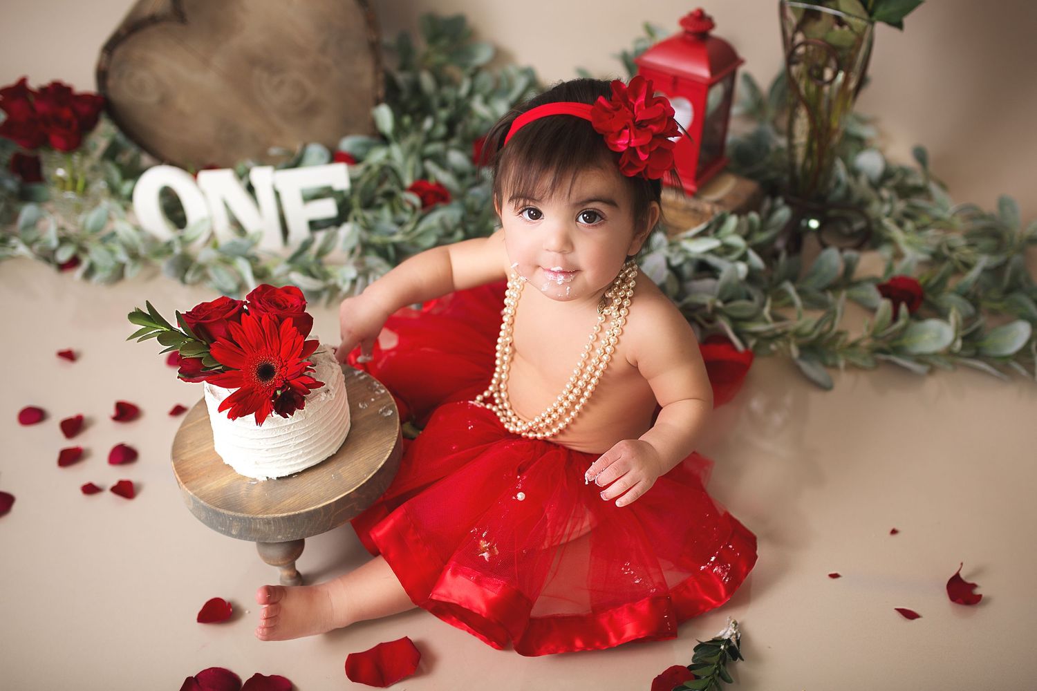 Holiday themed baby photo with red dress and Christmas decorations.