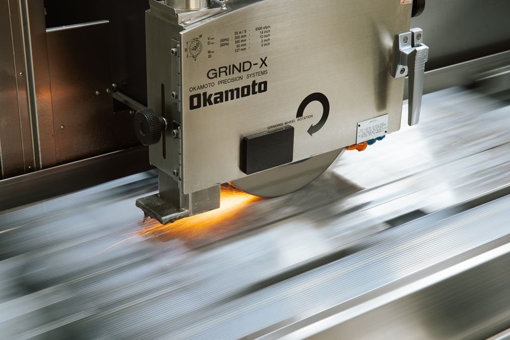 Detroit Commercial Photographer captures Industrial cutting machine in motion with illuminated cutting head moving across metal surface.