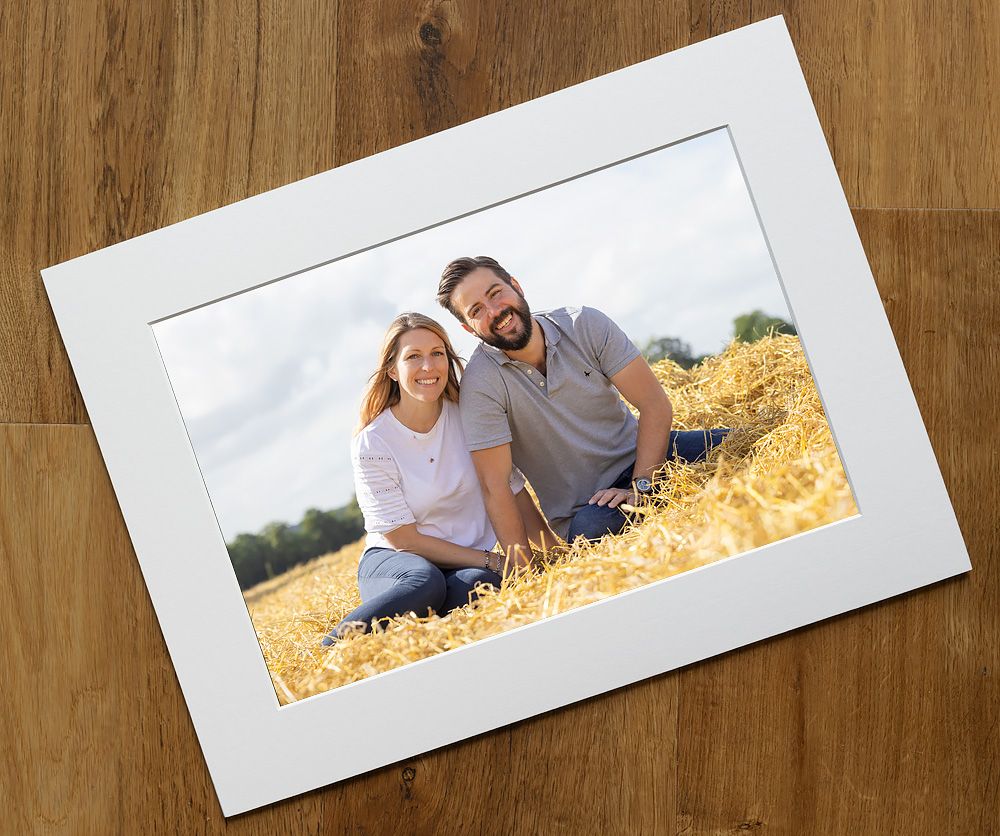 Panoramic view of white photo frames displayed on wooden background.