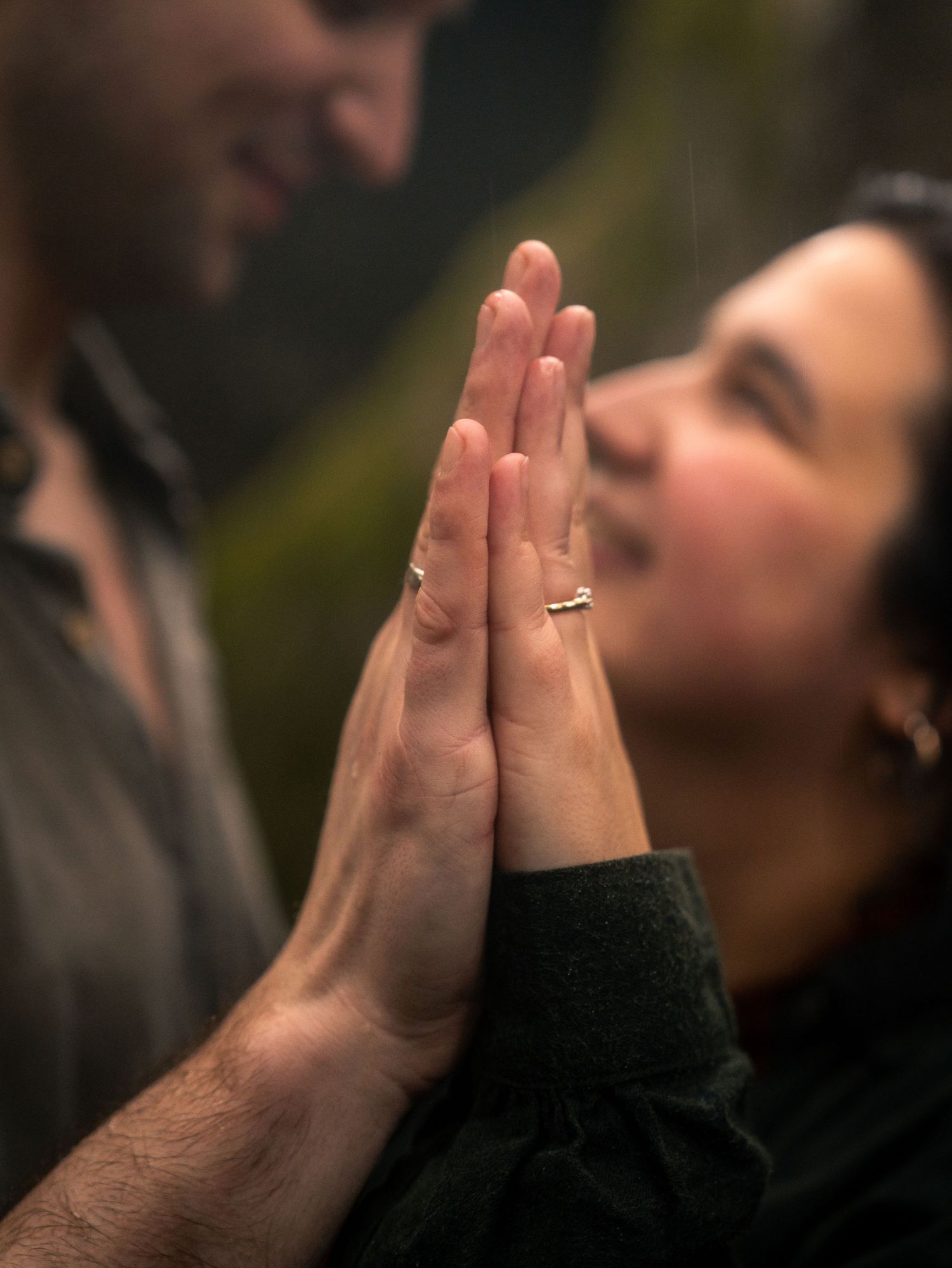 Intimate moment with hands pressed together in prayer position.
