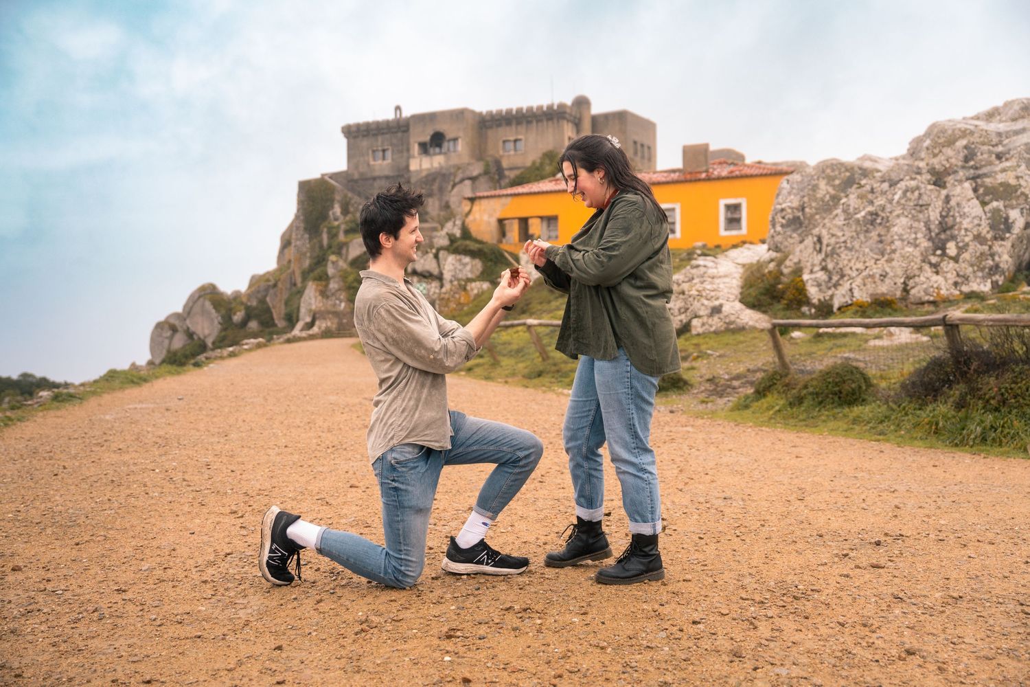 Proposal sequence captured at a scenic overlook with buildings and mountains in background.