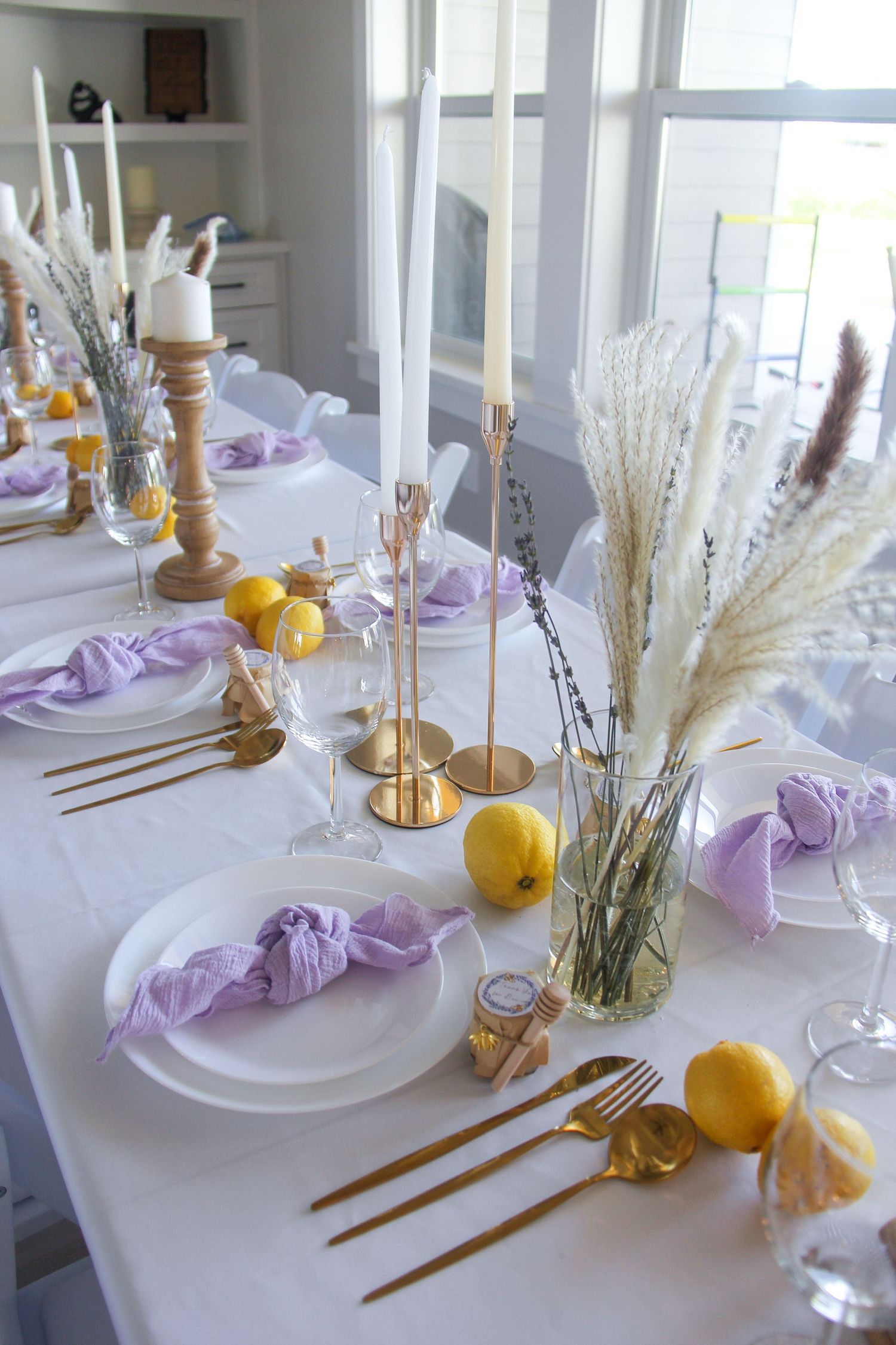 lilac and yellow baby shower guest table with tableware, candles, and flowers