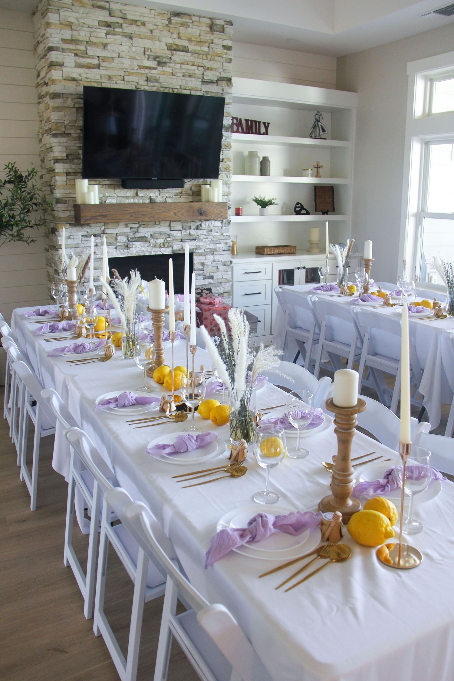 lilac and yellow baby shower guest table and chairs with tableware, candles, and flowers
