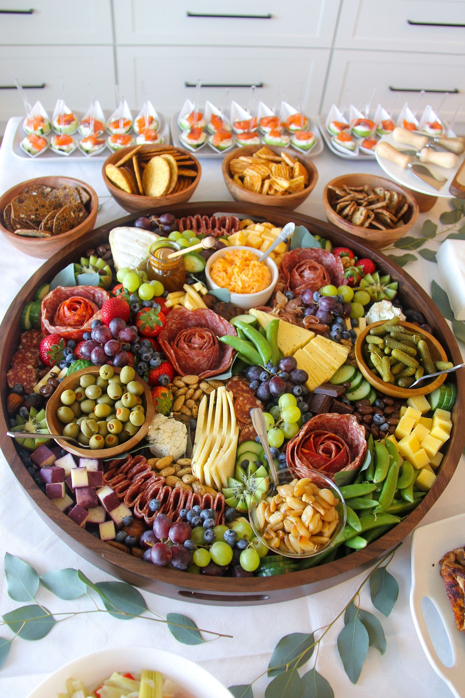 charcuterie board for baby shower with fruit, vegetables, deli meat, nuts, olives, and honey