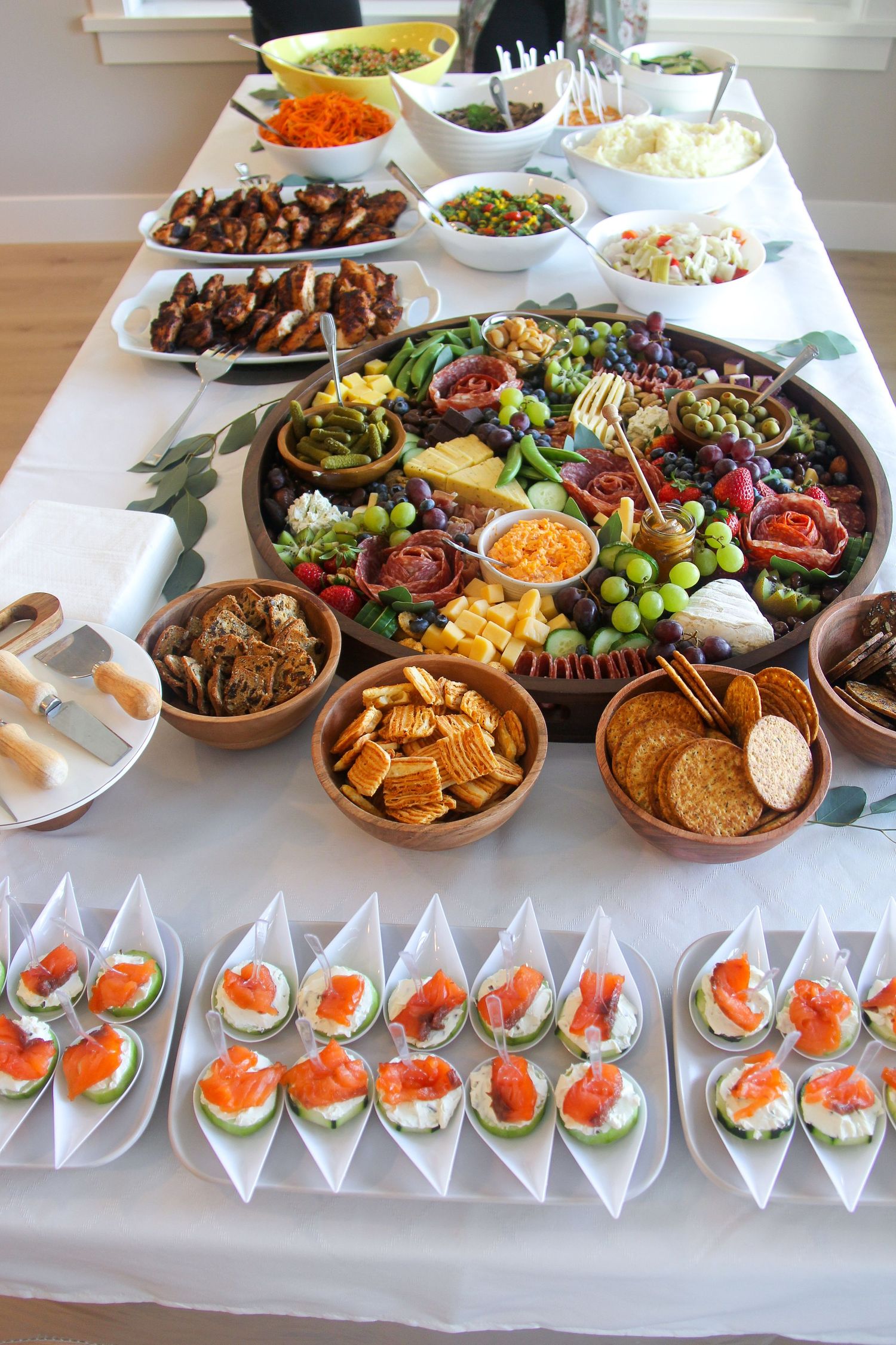 charcuterie board for baby shower with fruit, vegetables, deli meat, nuts, olives, and honey
