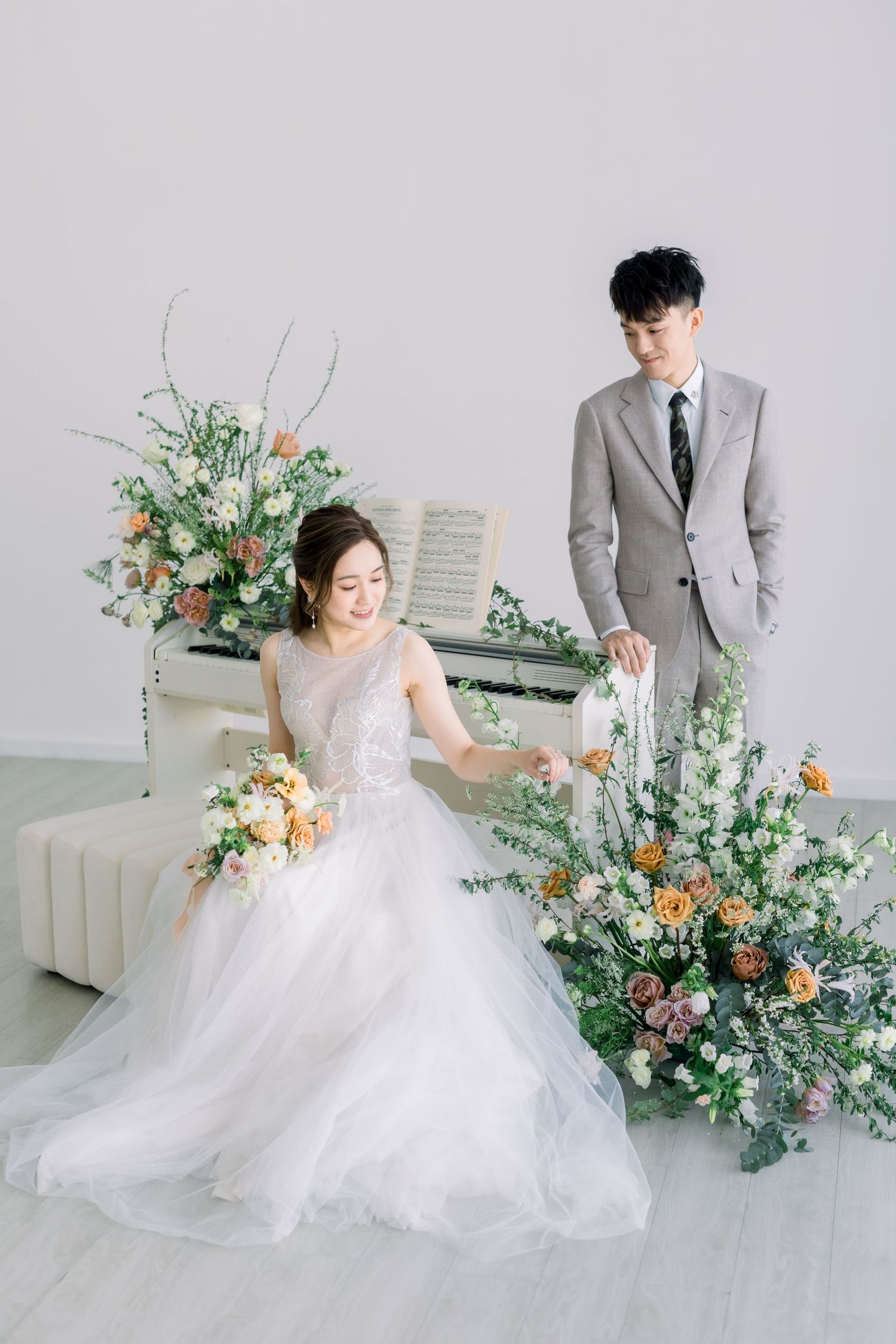 Elegant wedding photo with floral arrangements and bride in flowing white gown.