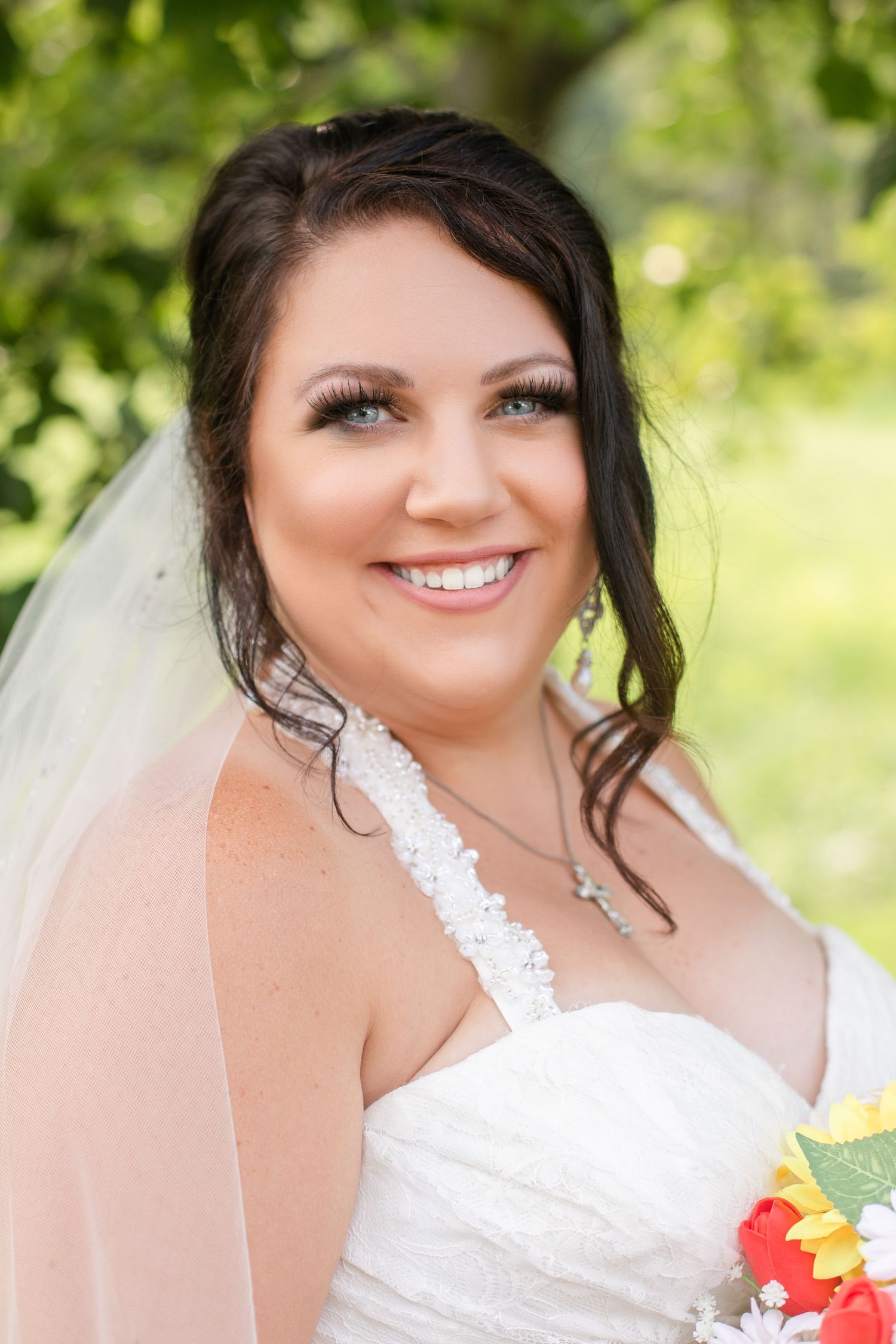 Bridal portrait in natural outdoor setting with sunflower bouquet.