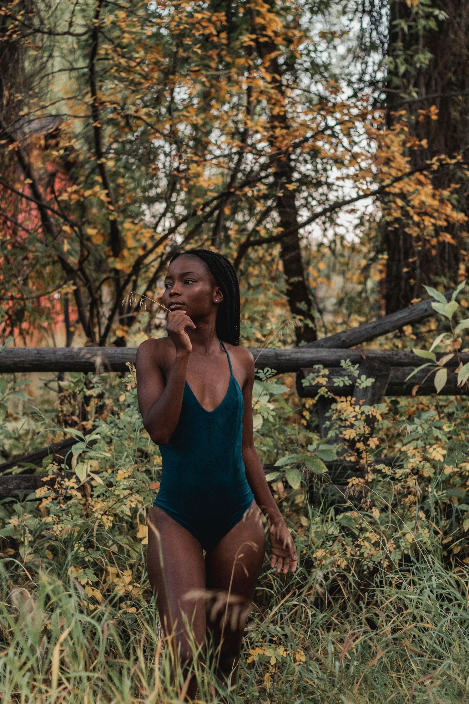 Artistic outdoor portrait session in a natural setting with autumn foliage.