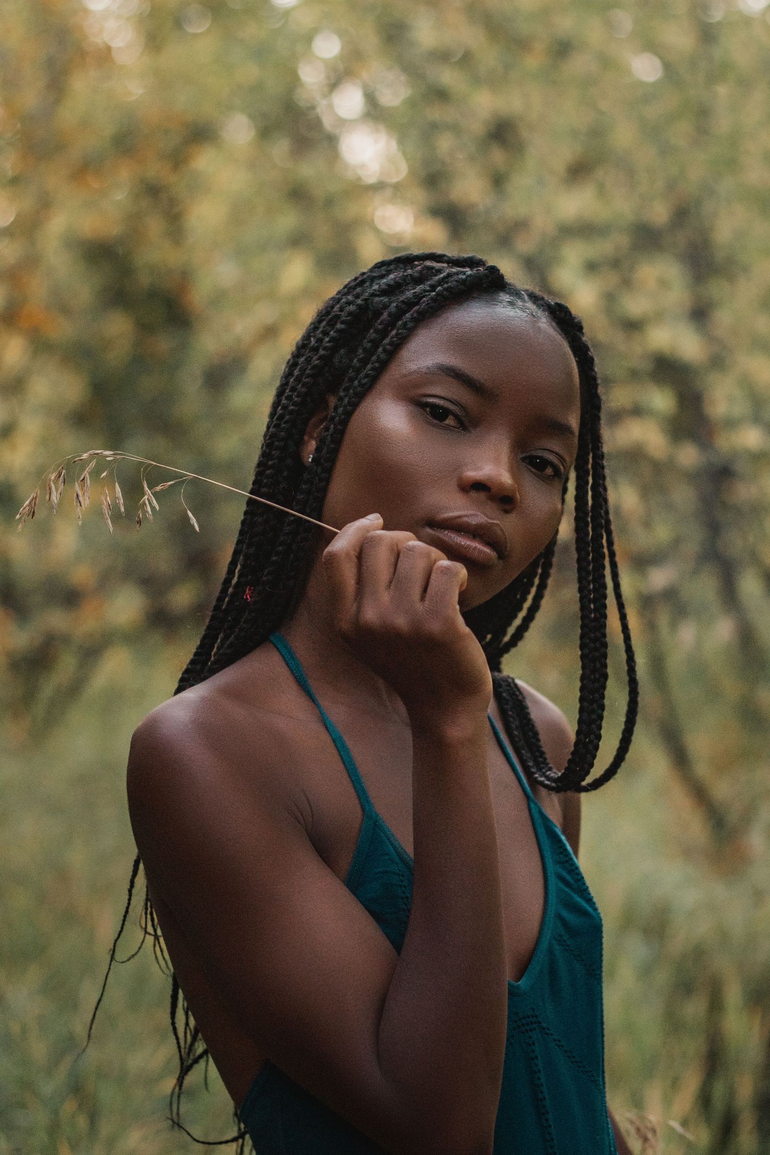 Candid portrait with natural lighting and bokeh effect in a wooded setting.