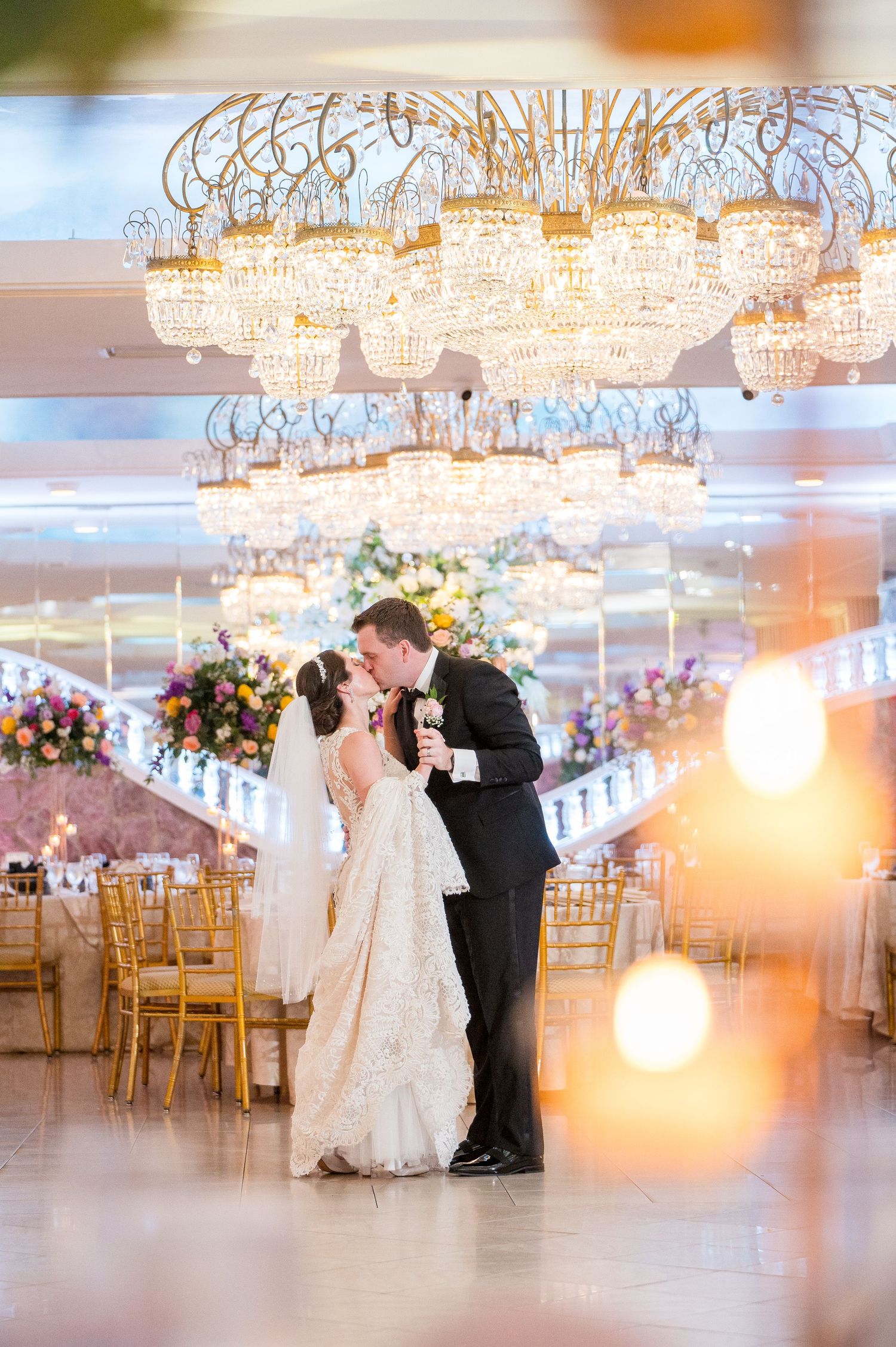Bride and groom kissing in the middle of the ballroom