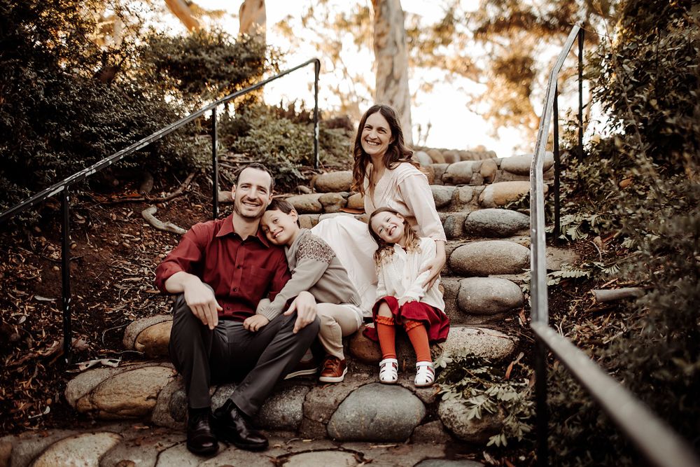parents and kids sit on stairs during playful family session