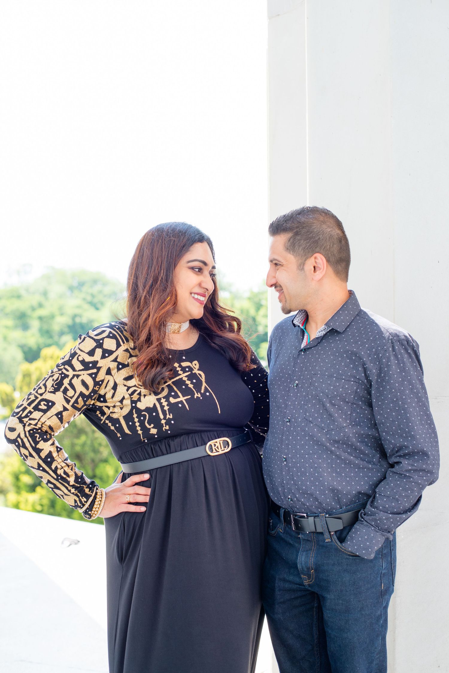 couple looks at each other by a column, outside