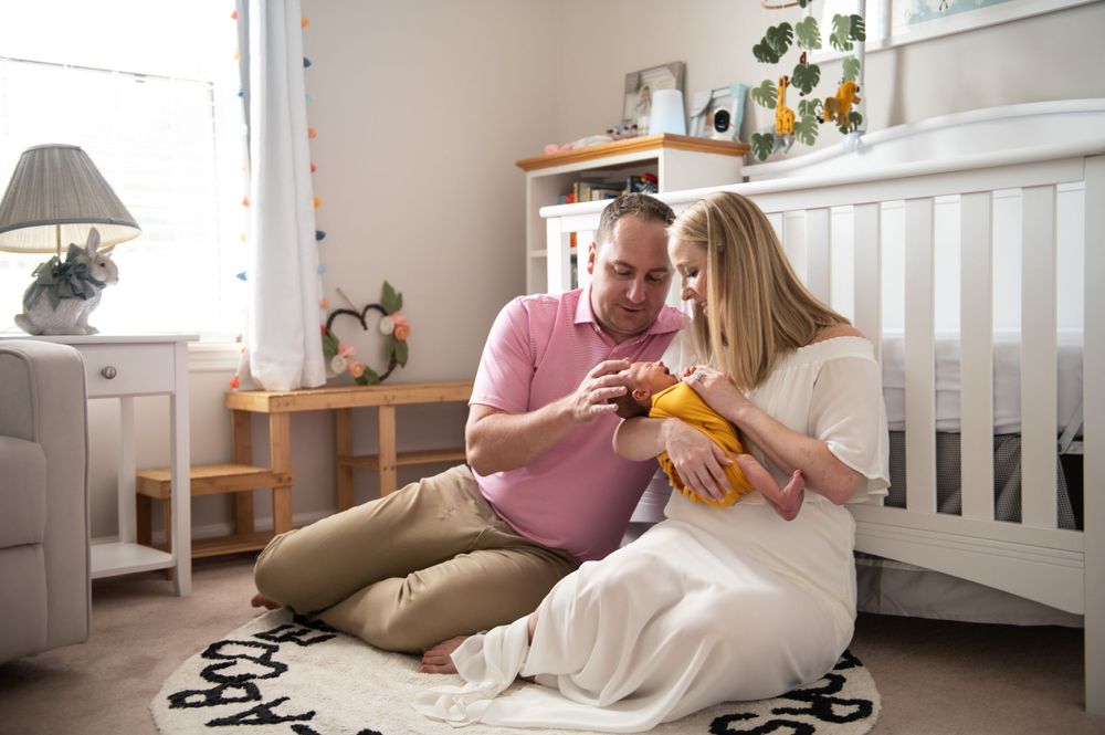 Family relaxing together on couch in nursery room with natural light.