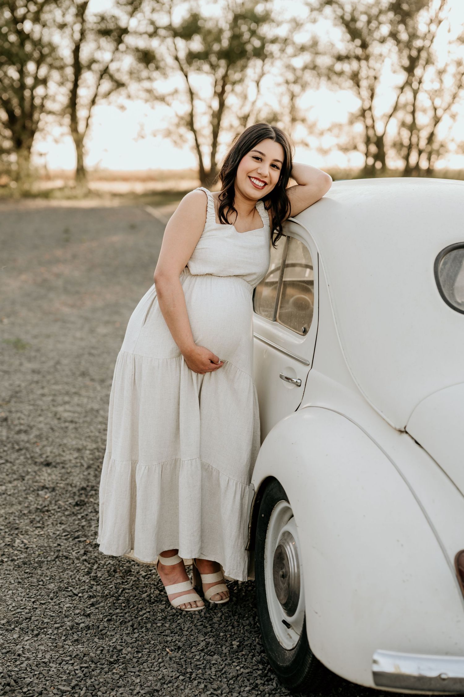 pregnant mom leaning on vintage VW bug for maternity session