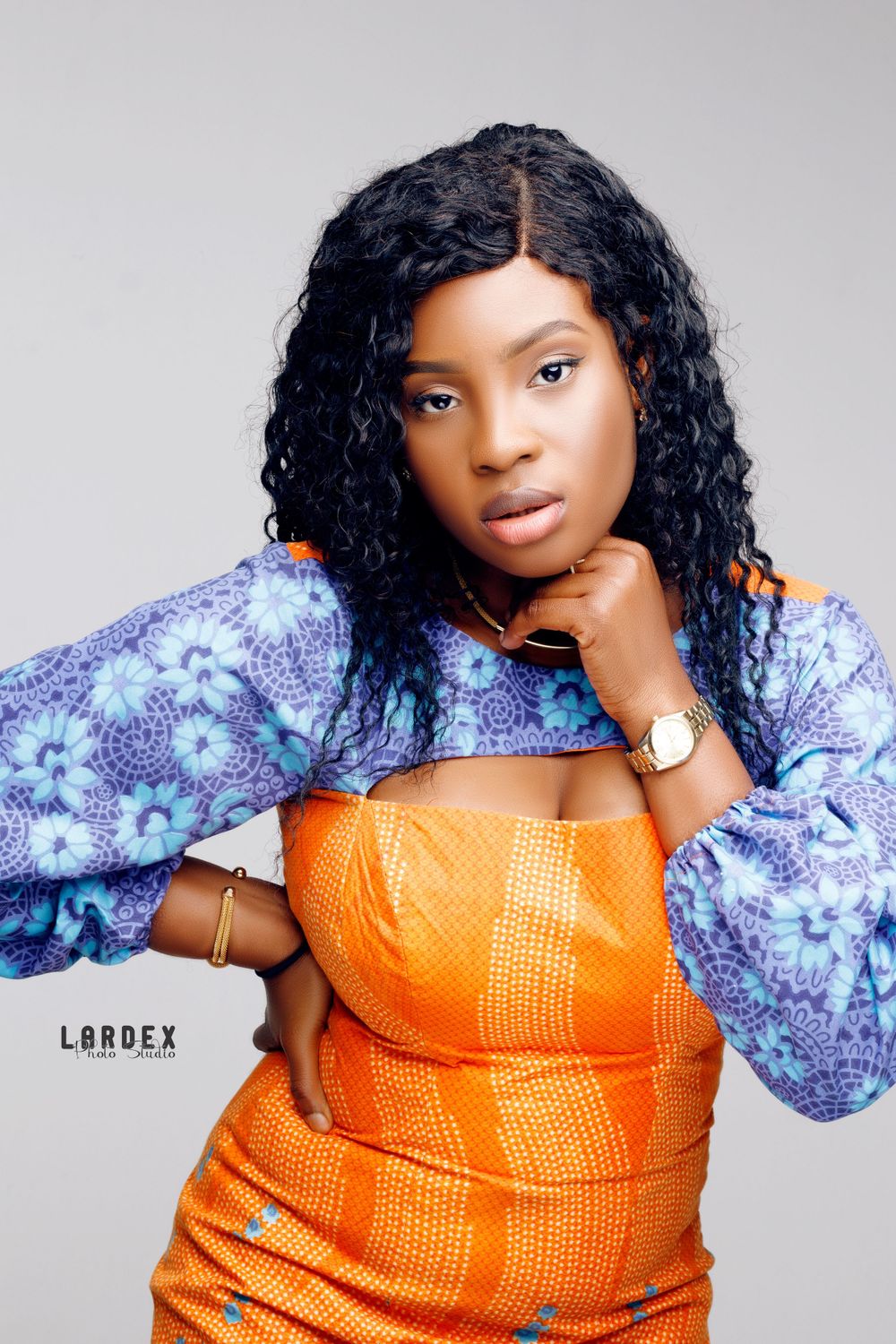 Fashion portrait featuring an orange corset dress with billowing purple patterned sleeves.