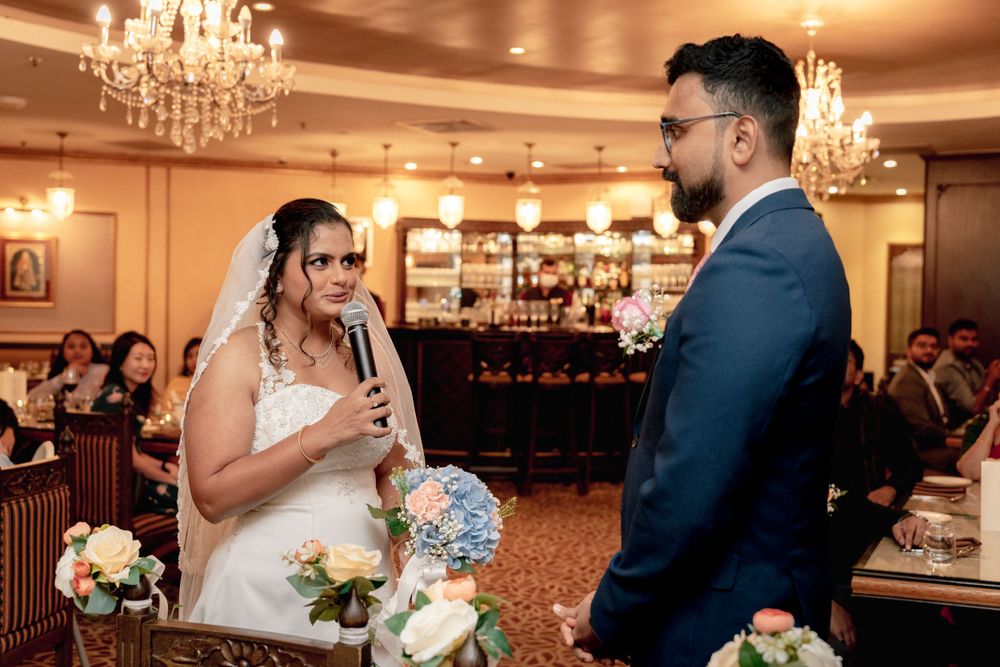 A couple shares emotional wedding vows in front of guests in an elegant ballroom setting.