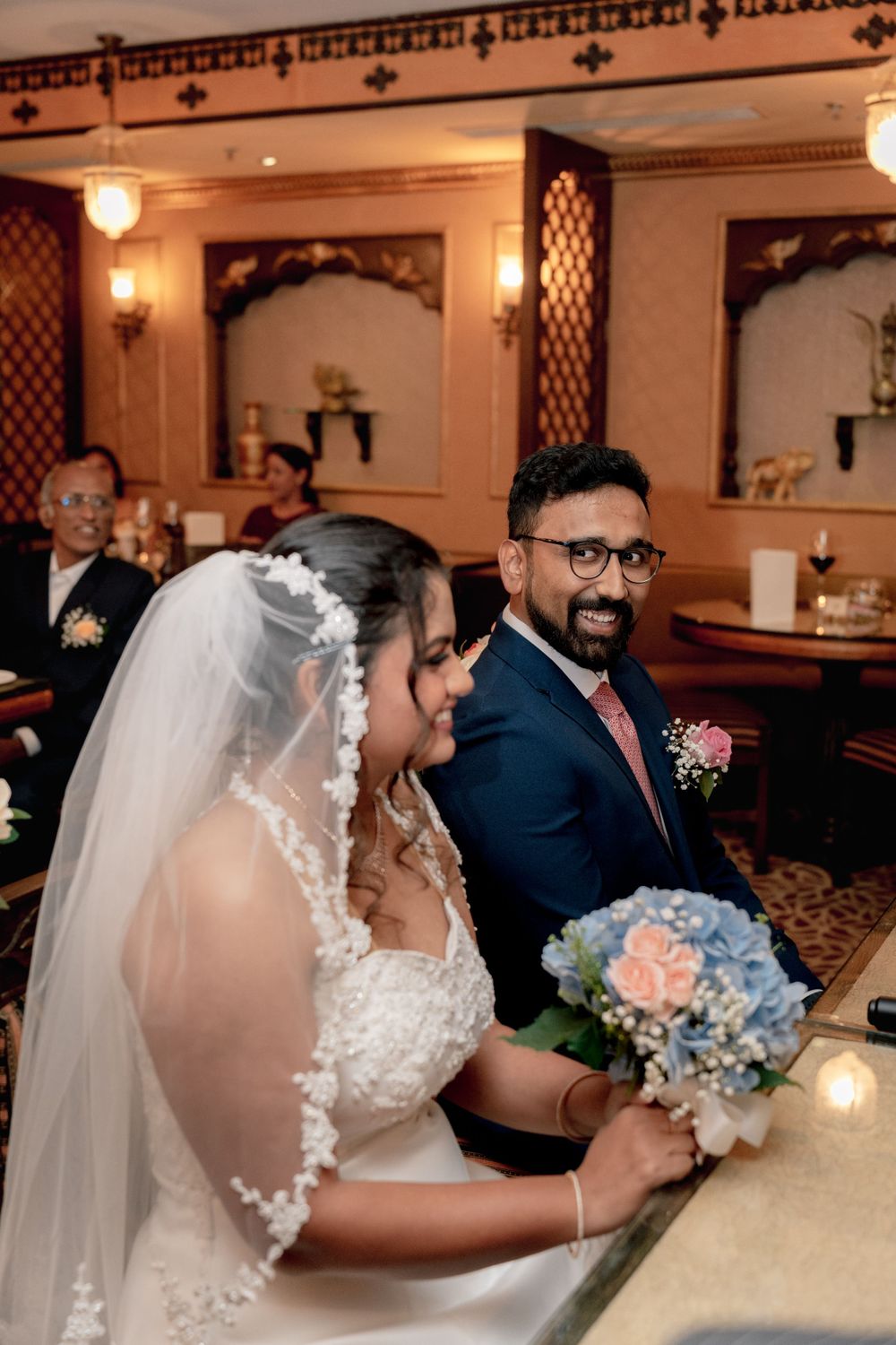 Newlyweds share a joyful moment during their wedding reception in an elegant venue.