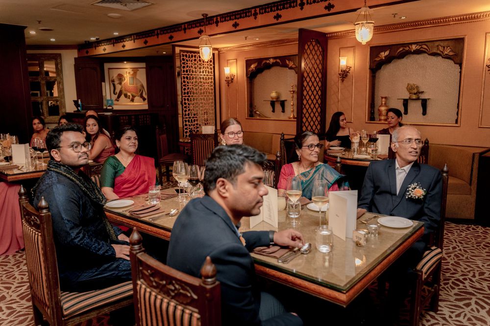 Wedding guests seated at elegantly decorated tables inside a restaurant venue with traditional decor.