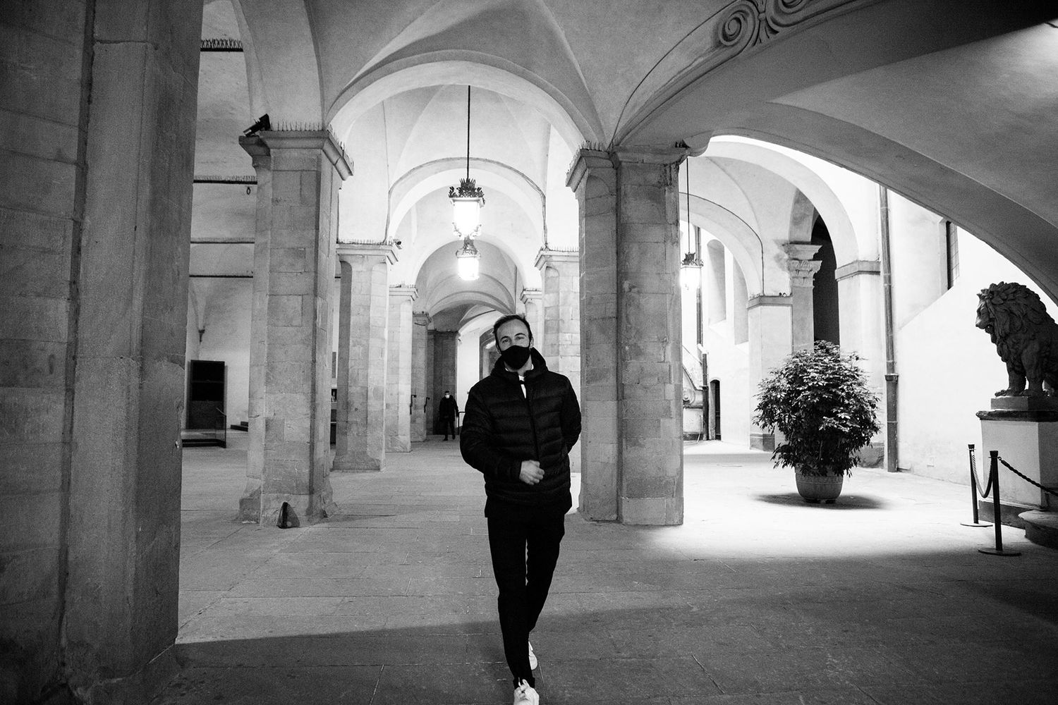 groom in a mask walking through Palazzo Vecchio Florence before his wedding