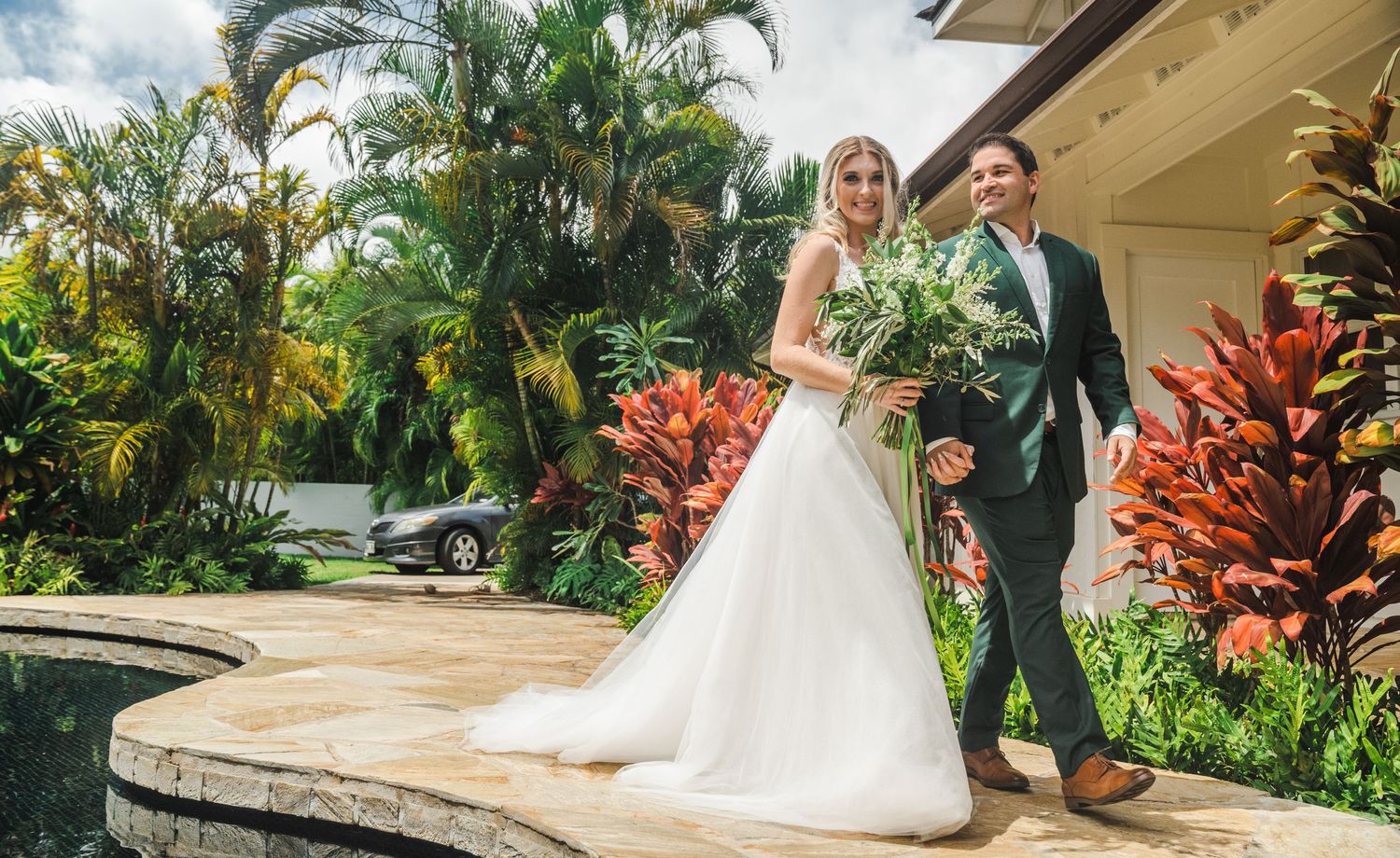 A beautiful wedding moment captured amongst vibrant tropical gardens and palm trees.