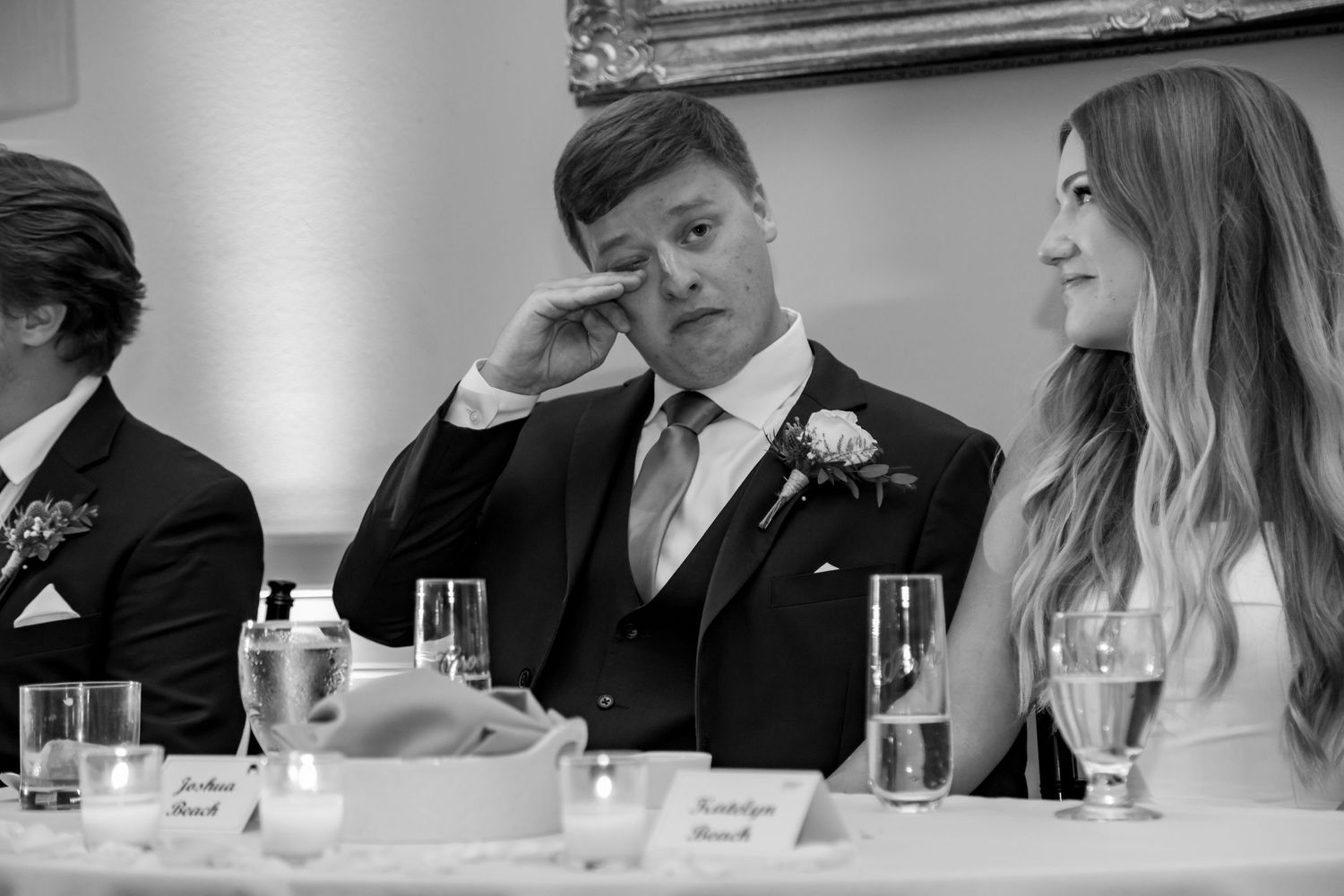 A candid reception moment captured in black and white during wedding speeches.
