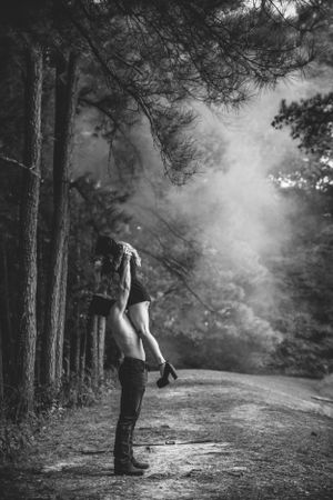 Atmospheric black and white forest scene with fog and dramatic silhouettes.