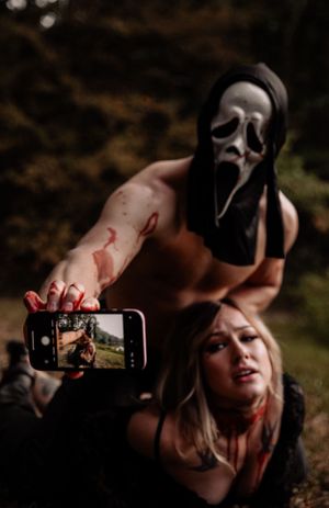 Dark artistic photoshoot with masks and mobile phone photography in moody forest setting.