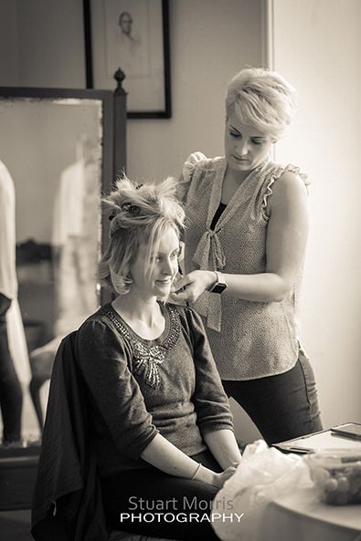 bridesmaid sitting down as the hairdresser does her thing