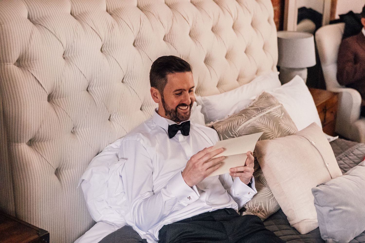 groom reading letter and smiling