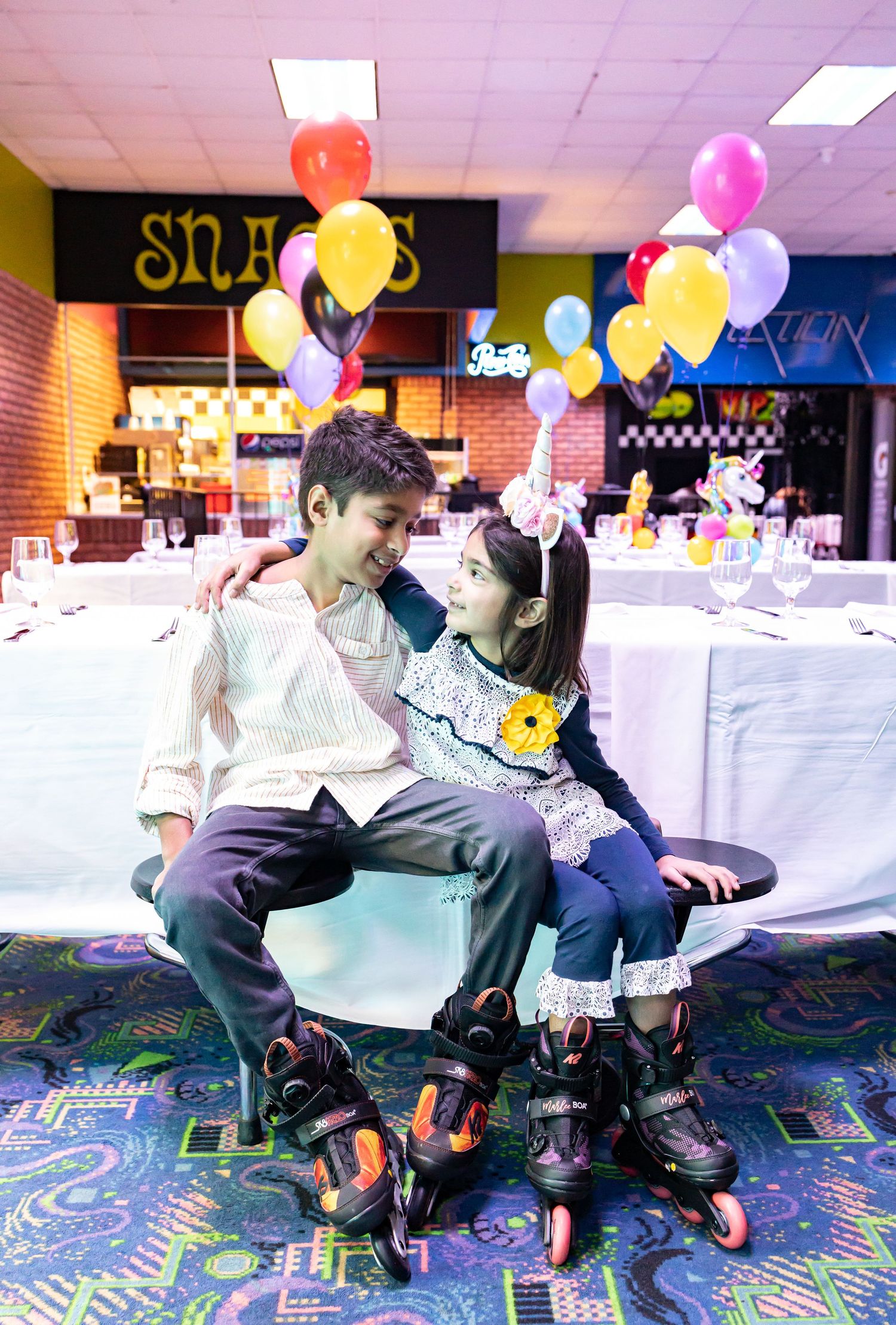 Event space with colorful balloons and decorations on a patterned carpet floor.