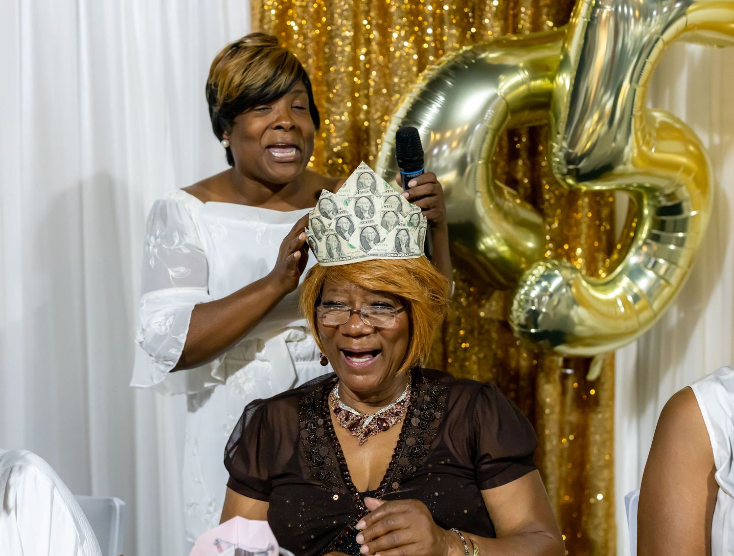 A celebratory moment with decorative gold balloons and a crown at a special event.