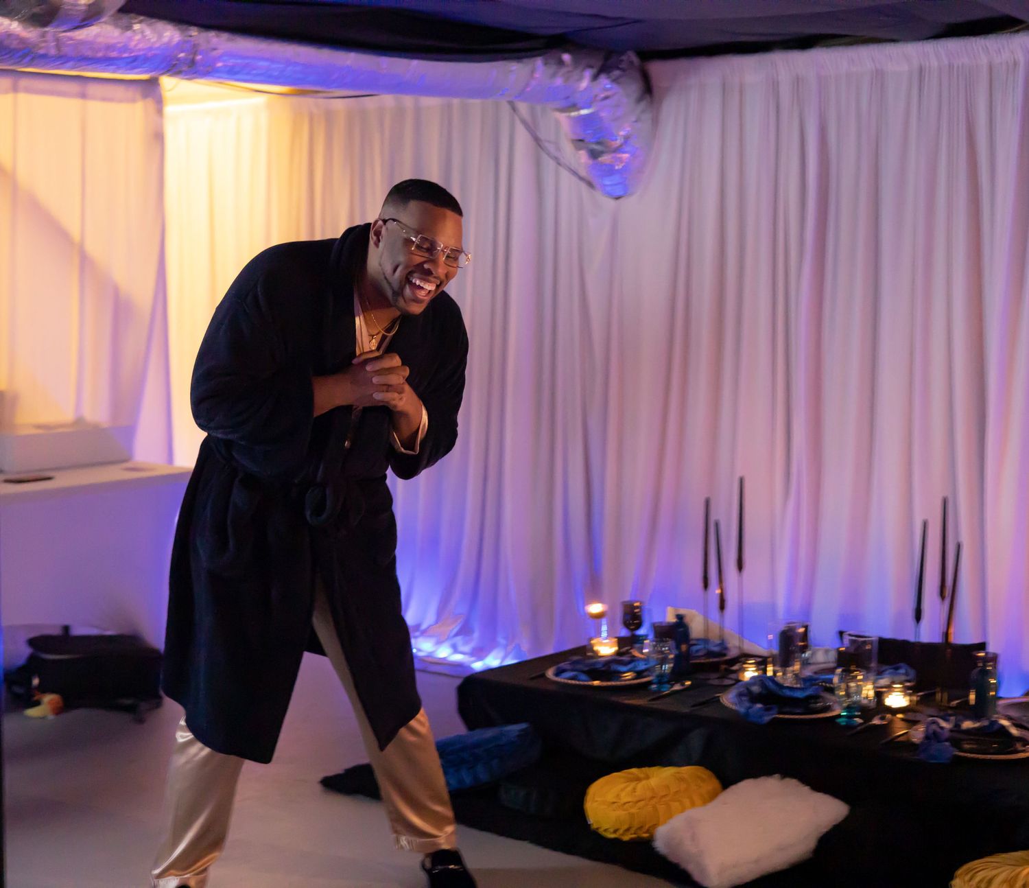 A performer in dramatic lighting entertains on stage during an event.