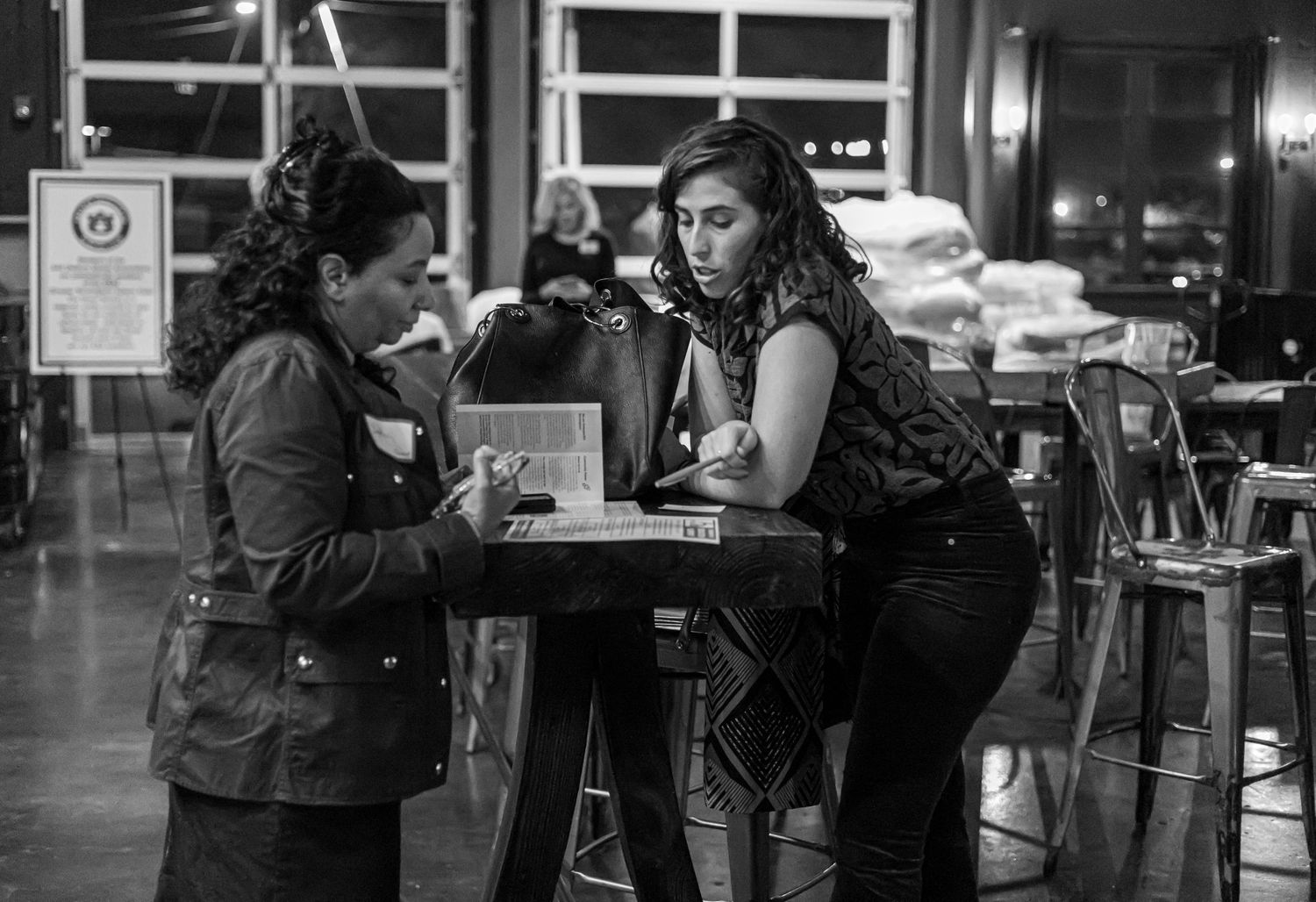 Two friends having an intimate conversation at a dimly lit cafe table.