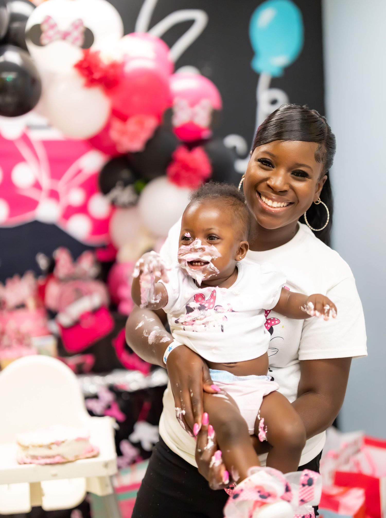 Birthday celebration with pink balloon decorations and cake in the background.