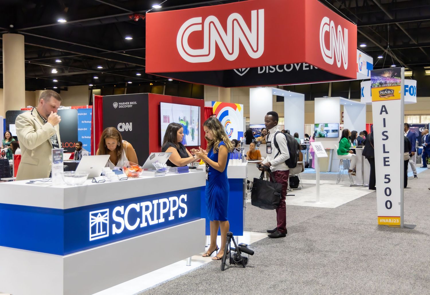 Job fair or career expo with CNN and Scripps booths visible in convention center.