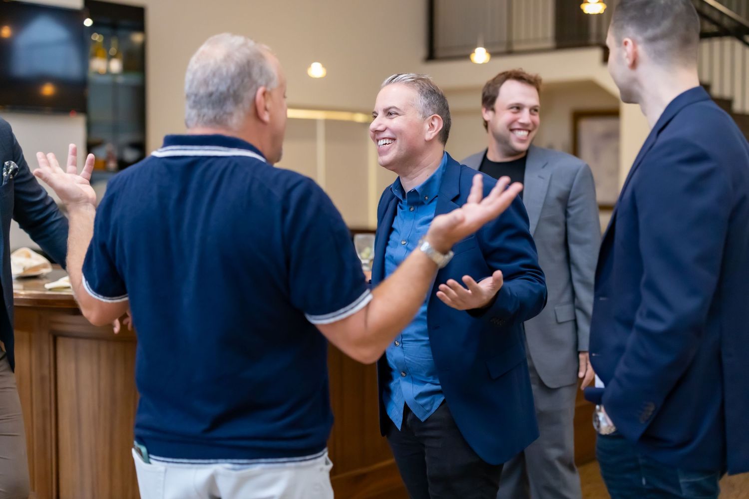 Business professionals engaged in animated conversation at a networking event.