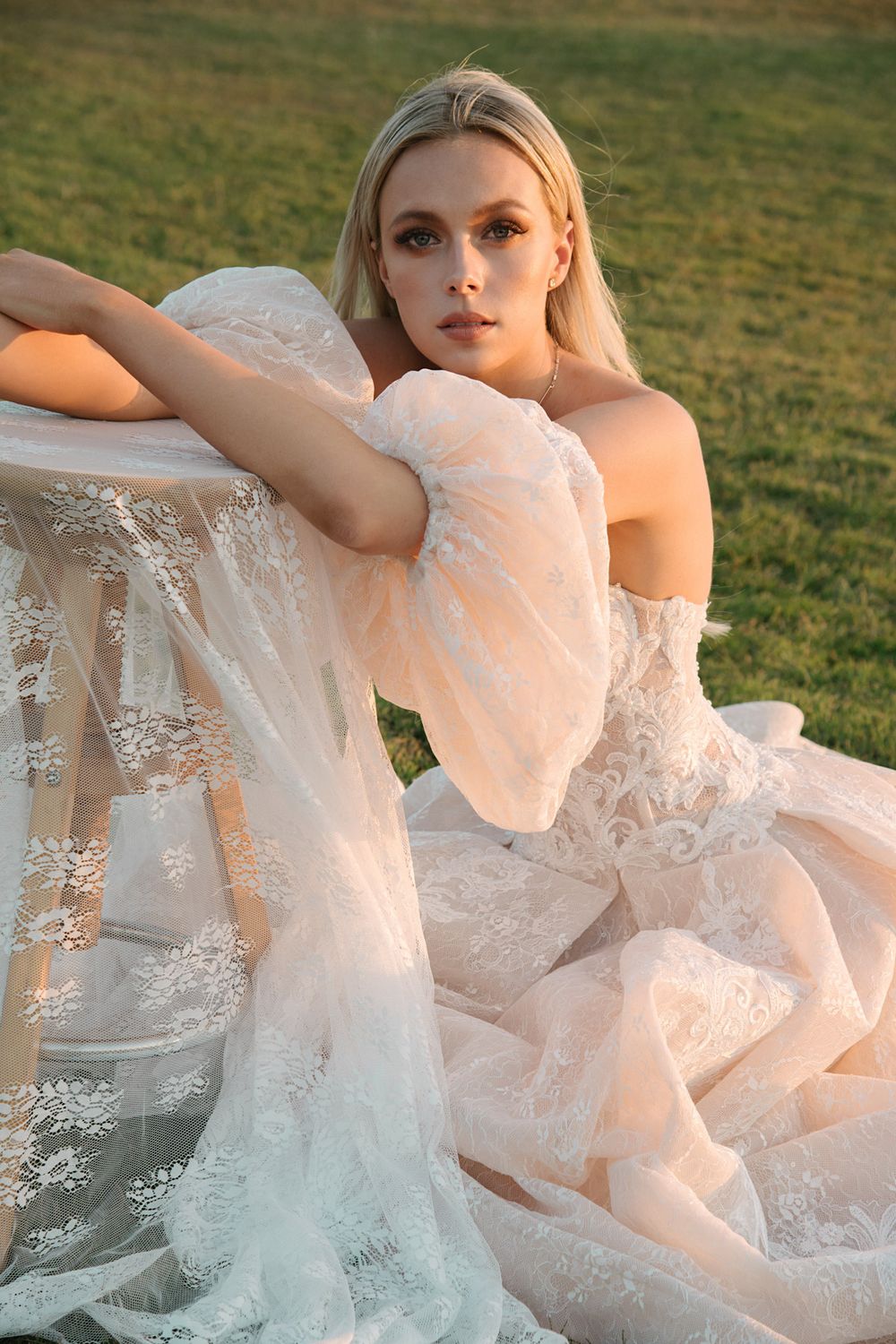 Close-up bridal portrait featuring intricate lace dress details in warm sunset light.