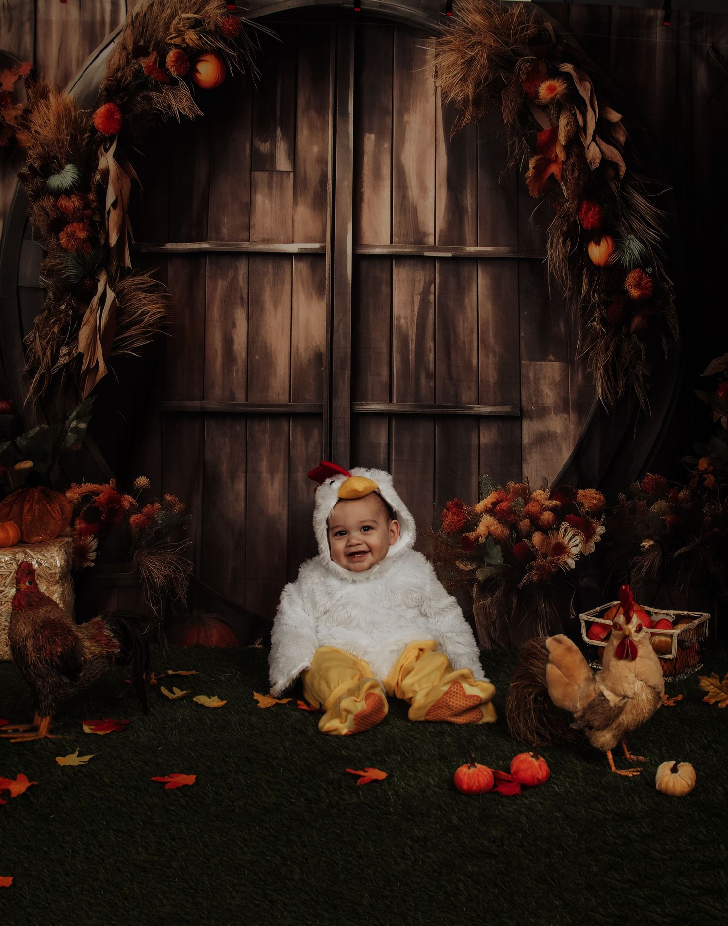 A festive Halloween photo setup with chickens and autumn decorations around a rustic wooden door backdrop.