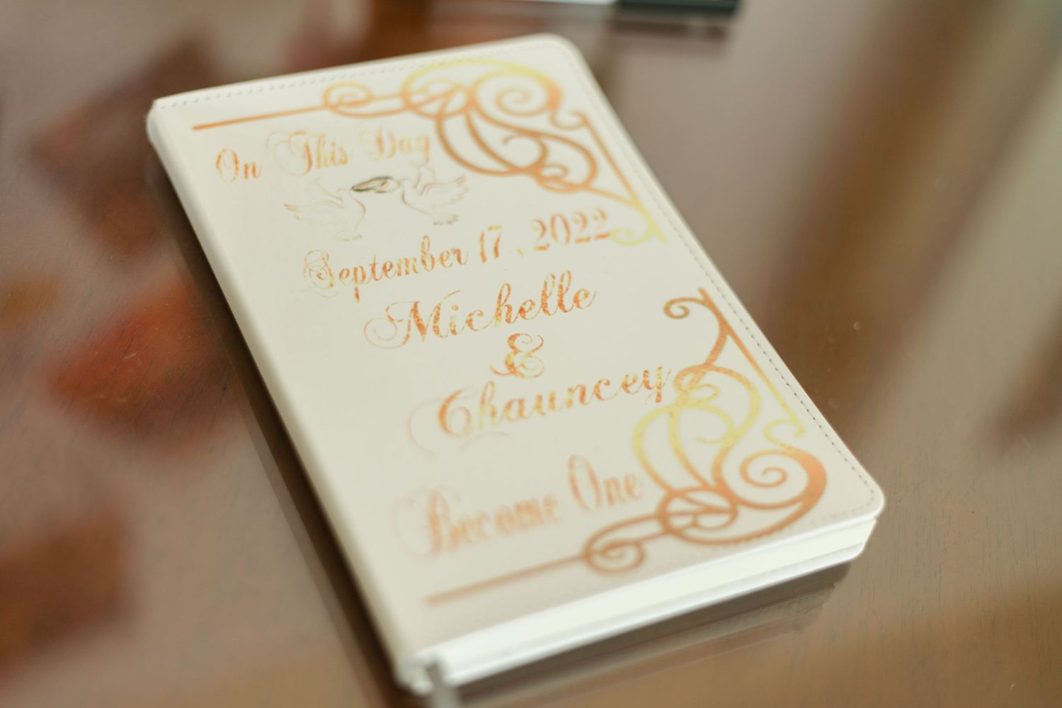 Elegant white wedding invitation cards with gold calligraphy and ornate designs.