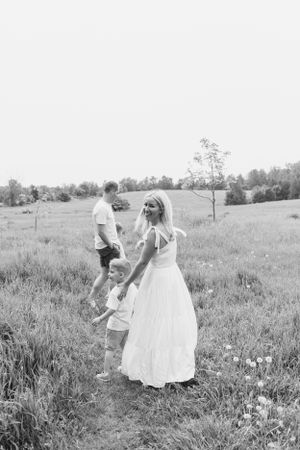 Black and white photo of people enjoying a summer day in a grassy meadow.